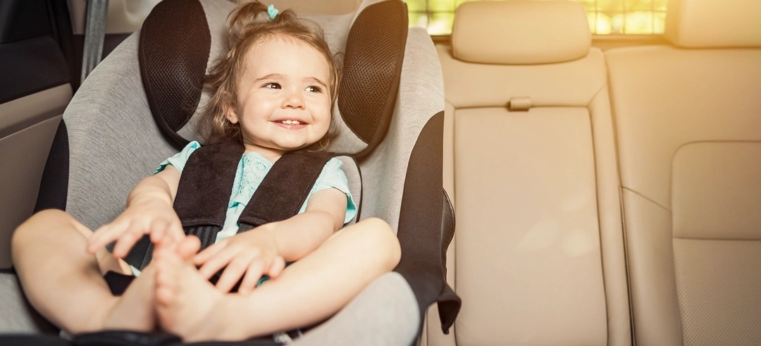 Bebé sentado en una silla de seguridad infantil dentro de un coche